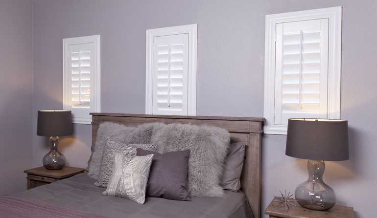 White plantation shutters in Southern California bedroom windows.